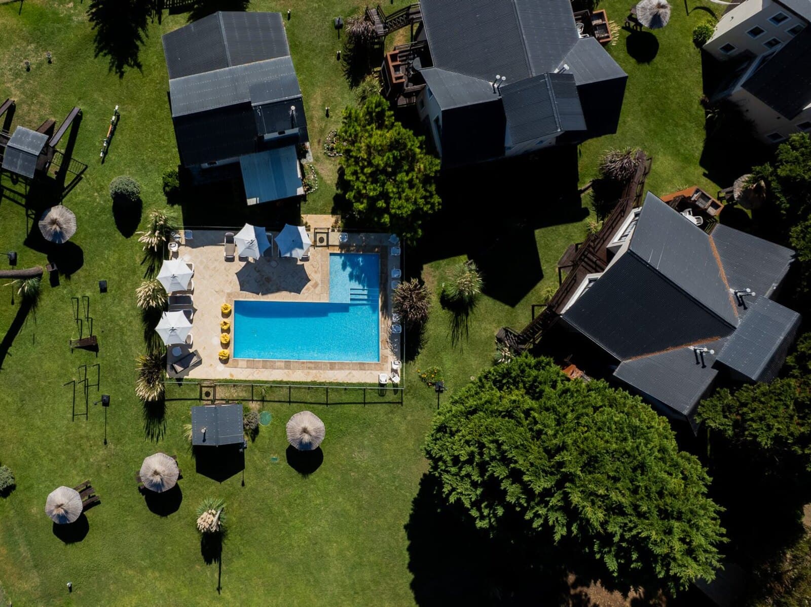 Vista aérea del complejo Kuei desde un dron: pileta, cabañas y parque